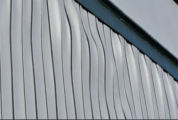 A vinyl siding panel buckled and wavy after being painted a dark color.
