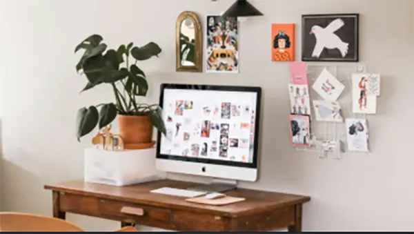 An overhead view of a tidy home-office desk with a cable tray, a labeled paper tray, and a small brass dish for loose items.