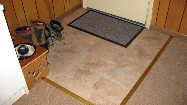 A tiled landing area by the entrance keeps slush off the carpet. 